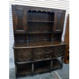 20th century oak sideboard with panelled cupboard doors flanking the two shelves, above a base of