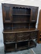20th century oak sideboard with panelled cupboard doors flanking the two shelves, above a base of