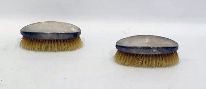 Pair of silver-backed hairbrushes of oval form with engine-turned decoration