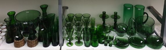 Large quantity of green glass tableware including a large bowl on pedestal foot, a set of 10 wine