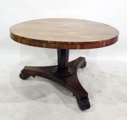 George III rosewood breakfast table with circular top and on octagonal tapering column support,