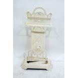 Cream painted cast iron umbrella stand with decorative back panel featuring sporting items, to