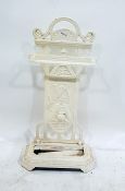 Cream painted cast iron umbrella stand with decorative back panel featuring sporting items, to