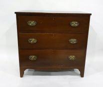 Antique mahogany chest of three long drawers with brass drop handles and oval backplates, on bracket