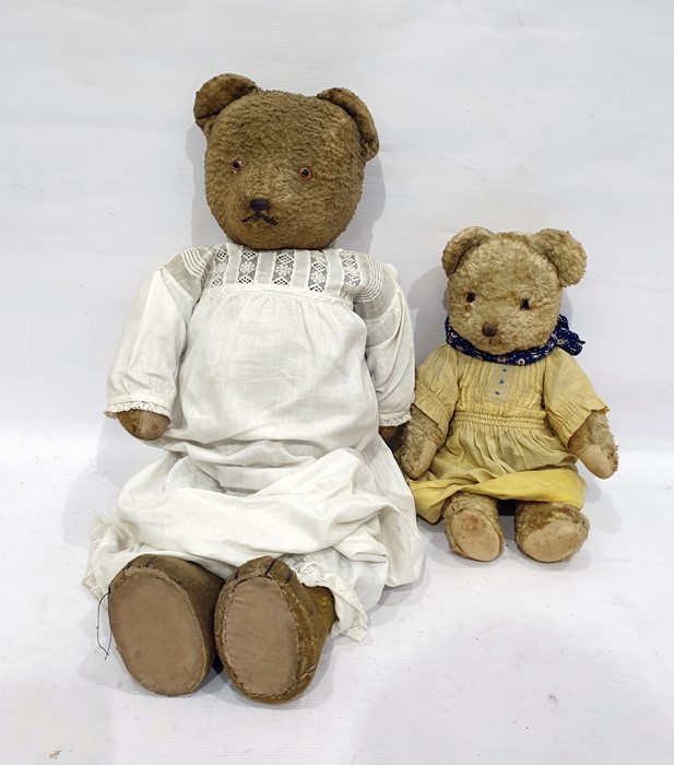 Large teddy bear with glass eyes and stitched nose, straw stuffed, in a white nightgown height 57cm,