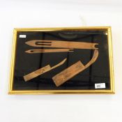 Weaving tools, possibly for fishing nets, within a framed glass-fronted box