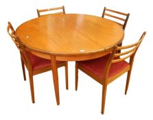 Teak G-Plan round extending dining table on tapering supports and four dining chairs with triple