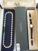 Gucci ladies watch, gilt and black, leather strap, boxed, string of faux pearls, double strand