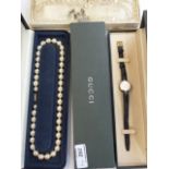 Gucci ladies watch, gilt and black, leather strap, boxed, string of faux pearls, double strand