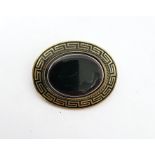 Rolled gold, black enamel and onyx brooch, oval, set single polished oval stone, flat-topped, and