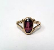 Gold ring set with a central oval garnet, with split shoulders (unmarked) (with damage)