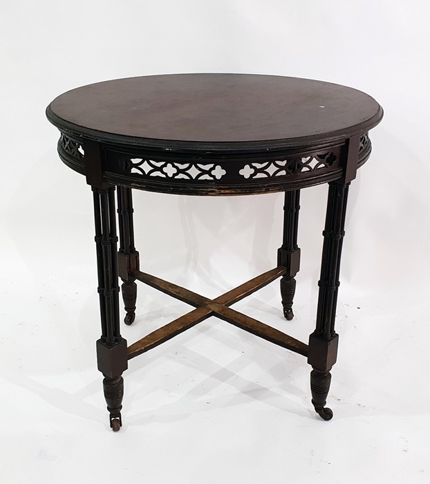 Stained mahogany circular centre table with moulded edge over carved and pierced frieze, raised upon