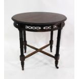 Stained mahogany circular centre table with moulded edge over carved and pierced frieze, raised upon