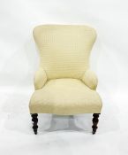 Cream ground upholstered low armchair on turned front supports to castors