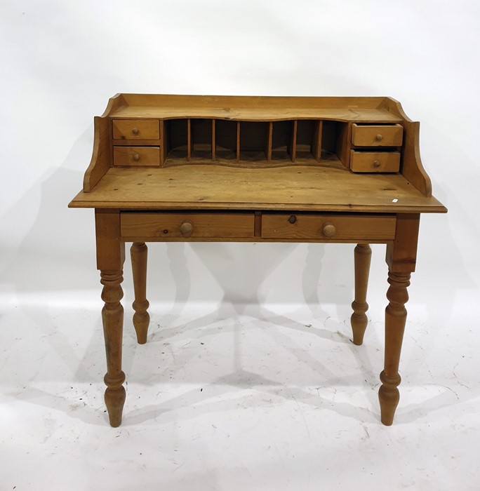 Old pine writing table, the back fitted with pigeonholes and four short drawers, two frieze drawers,