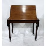 19th century mahogany desk, the raising top with drop-leaf sides, on turned supports to brass caps