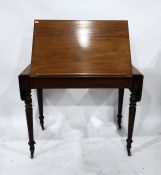 19th century mahogany desk, the raising top with drop-leaf sides, on turned supports to brass caps