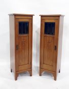 Pair of Art Nouveau style narrow single door cabinets, the square tops with moulded edges, above the