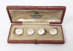 Set of four gold and mother-of-pearl dress buttons, each of circular form set with a central