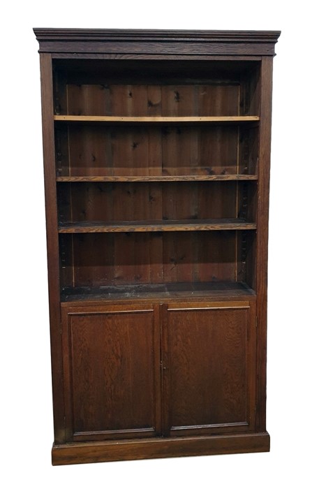 Old oak open bookcase with straight moulded cornice, adjustable shelves, cupboard below enclosing