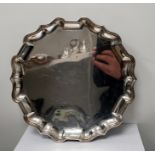 Silver salver by Mappin & Webb, London 1911, of shaped circular form, on three hoof feet, 32cm