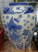 Oversized ovoid Chinese-style ceramic urn decorated in blue with fishes and dog head relief around