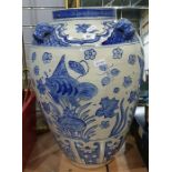 Oversized ovoid Chinese-style ceramic urn decorated in blue with fishes and dog head relief around