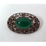 Silver and green hardstone brooch, set single polished oval stone, having openwork surround of
