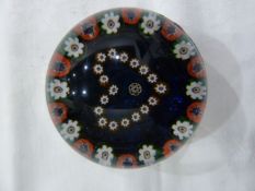 Millefiori decorated paperweight with stylised love-heart to the centre, on a blue field