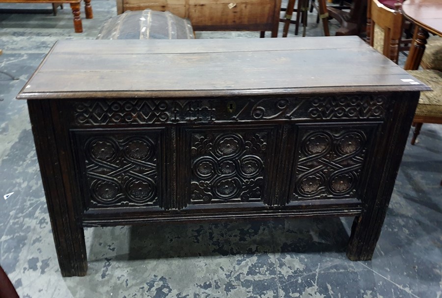 17th century oak coffer, the rectangular top with moulded edge, above the carved front emblazed with
