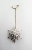 Gold and diamond set star brooch, the central brilliant cut diamond approx 0.3ct and surrounded by