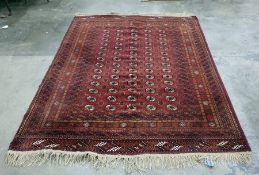 Eastern rug on red ground with four rows of 14 elephant foot guls, 273cm x 203cm