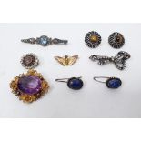 Gold-coloured amethyst brooch, the central oval amethyst surrounded by a border of flowerheads,