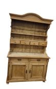 Old pine dresser with arched pediment, open shelf plate rack with four spice drawers, pair of frieze