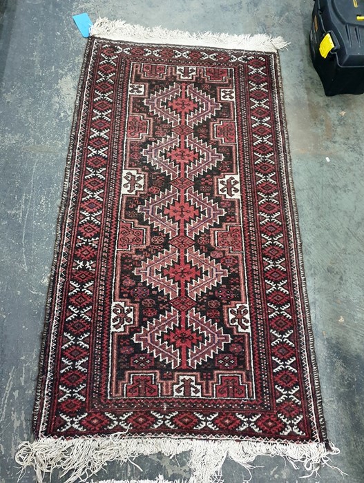 Eastern rug in red, black and cream, with five central medallions and stepped margin, 143cm x 78cm