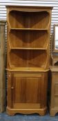 Modern pine Ercol corner cupboard with three open shelves, cupboard below enclosing shelf, on