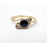 Gold, sapphire and diamond ring set central circular sapphire flanked by two smaller diamonds, in