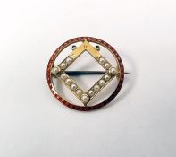 Edwardian gold brooch of circular form with a red enamel border and central square set with