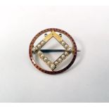 Edwardian gold brooch of circular form with a red enamel border and central square set with