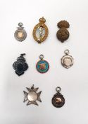 Six various silver and silver-coloured fobs, some with engraving and two military cap badges