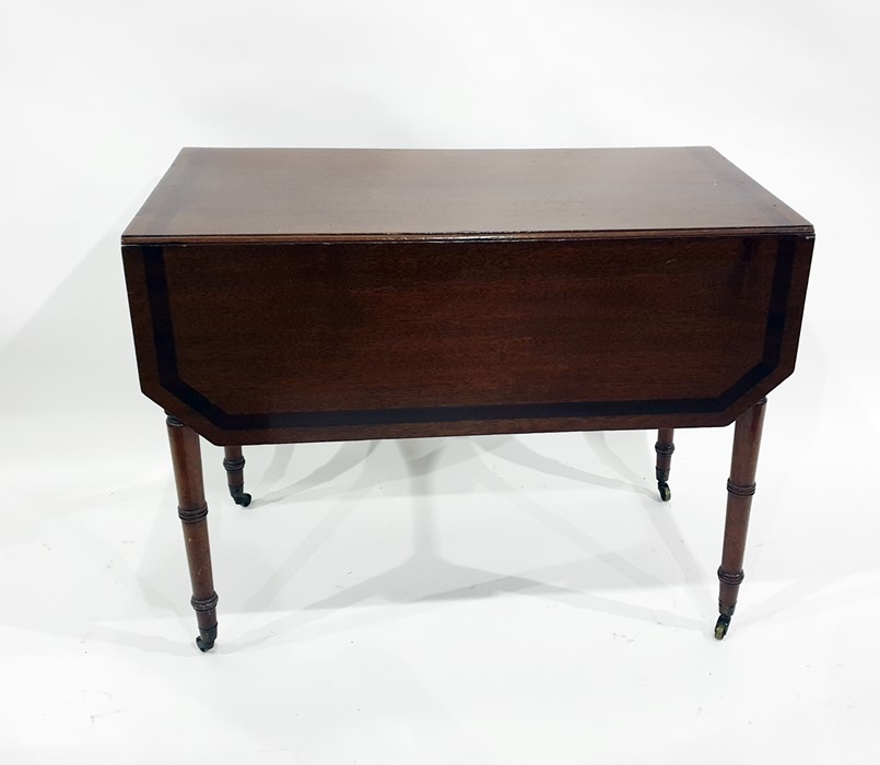 19th century mahogany pembroke table with cross-banded top, on turned supports to brass caps and