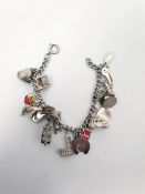 White metal curb-link charm bracelet hung with silver and other assorted charms