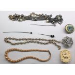 Assorted costume jewellery including agate stickpin, faux pearls, brooches, a hammered silver-