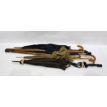 Carved wooden walking stick with knop handle, two black umbrellas, one with gold collar, the other