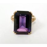 9ct gold dress ring set with an emerald-cut synthetic corundum, with pierced collet and shoulders,