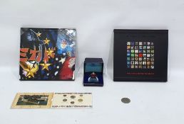 Two commemorative royal mail stamp albums, a small collection of coins and a paperweight inset