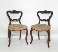 Four mahogany balloon back chairs with carved top rail and back bar, serpentine fronted, overstuffed