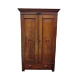 Early 20th century oak two-door wardrobe with moulded pediment above two cupboard doors, featuring