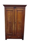 Early 20th century oak two-door wardrobe with moulded pediment above two cupboard doors, featuring