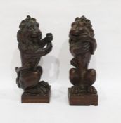 Pair carved hardwood model lions, sejant, front le